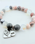 Beaded bracelet with a heart-shaped charm on a white background