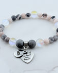 Beaded bracelet with heart-shaped charms on a marble surface