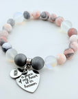 Beaded bracelet with heart-shaped charm on a light background
