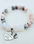 Beaded bracelet with 'MOM' charm on a light background