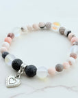Bracelet with multicolored beads and a heart charm on a light background