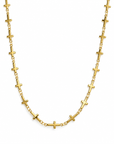 A gold chain necklace featuring multiple small, polished cross links spaced evenly along the chain, displayed against a solid white background.