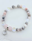 Beaded bracelet with a heart charm on a light background
