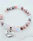 Beaded bracelet with a 'Granddaughter' heart charm on a marble surface