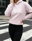Person wearing a pink hoodie with 'PRAISE THE LORD' text on a crosswalk.