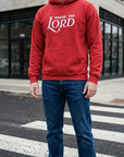 Person wearing a red hoodie with 'Praise the Lord' text on a street.