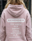 Person wearing a pink hoodie with a motivational message on the back.