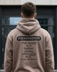 Person wearing a beige hoodie with a motivational message on the back, standing on a zebra crossing.