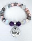 Beaded bracelet with a silver charm featuring a motivational quote on a white background