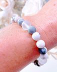 The original 5 Second Rule gemstone stretch bracelet made with pink zebra jasper beads and translucent aura beads is worn on a wrist. Natural neutral colors.