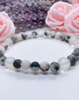The 5 Second Rule Companion gemstone stretch bracelet made with pink zebra jasper beads and translucent aura beads sits on a white table. Natural neutral colors.