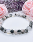 The 5 Second Rule Companion gemstone stretch bracelet made with pink zebra jasper beads and translucent aura beads sits on a white table. Natural neutral colors.