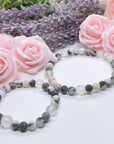 The 5 Second Rule Companion gemstone stretch bracelet made with pink zebra jasper beads and translucent aura beads sits on a white table. Natural neutral colors.