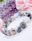 The original 5 Second Rule gemstone stretch bracelet made with pink zebra jasper beads and translucent aura beads sits on a white table. Natural neutral colors.