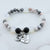 Beaded bracelet with 'Mom' and heart-shaped charm on a white background