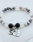 Beaded bracelet with 'Mom' and heart-shaped charm on a white background