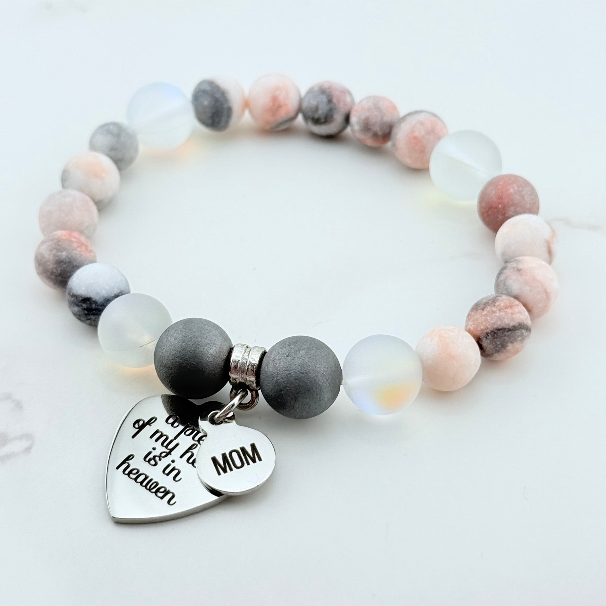 Beaded bracelet with a heart-shaped charm on a white background
