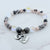 Beaded bracelet with heart-shaped charms on a marble surface