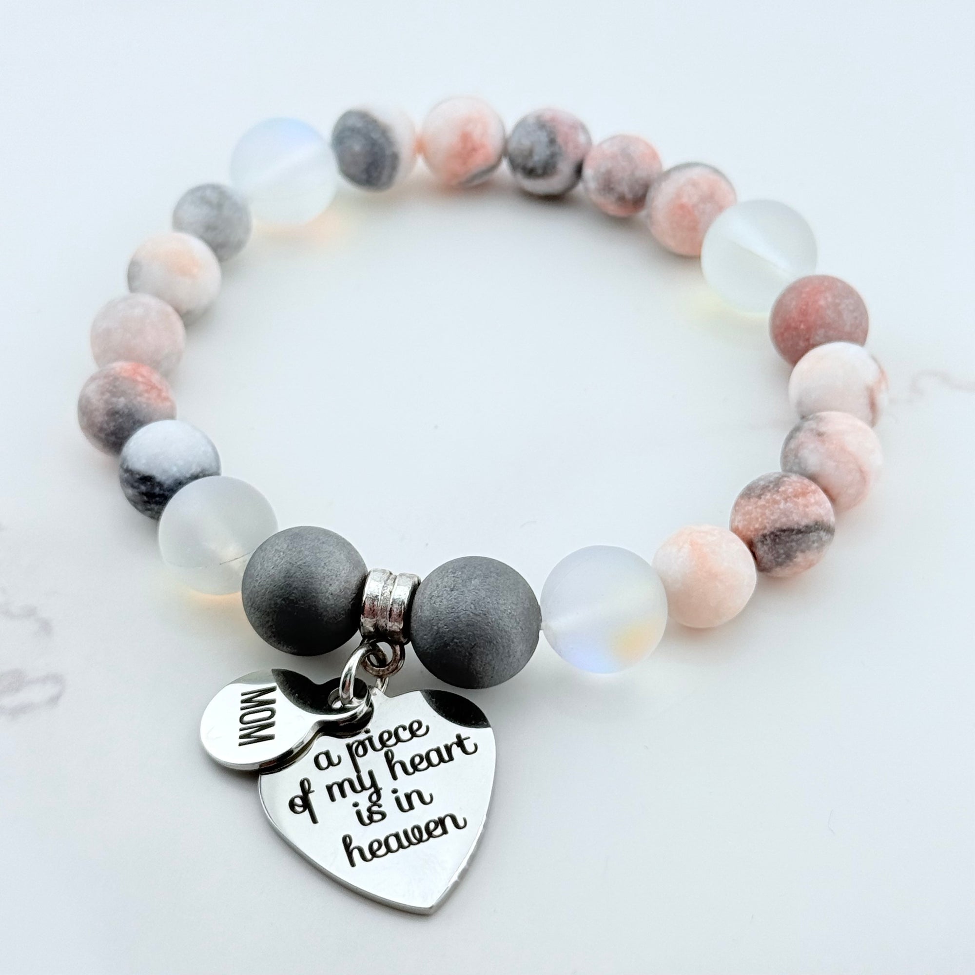 Beaded bracelet with heart-shaped charm on a light background