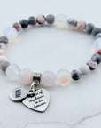 Beaded bracelet with heart-shaped charm on a marble surface
