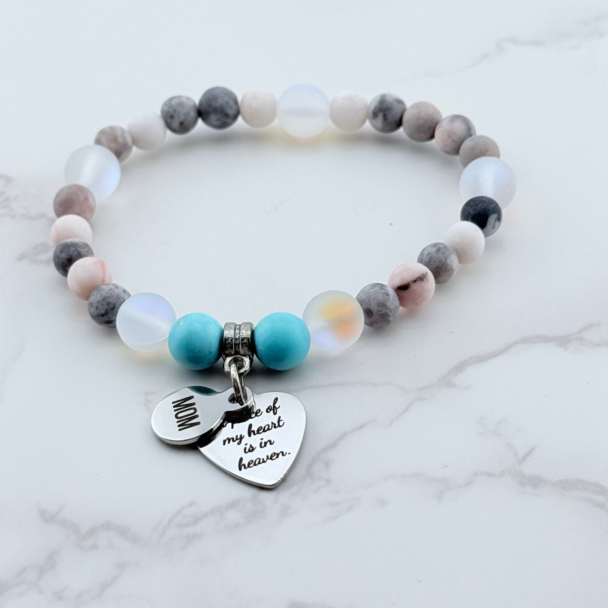 Beaded bracelet with heart-shaped charms on a marble background