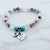 Beaded bracelet with heart-shaped charms on a marble background