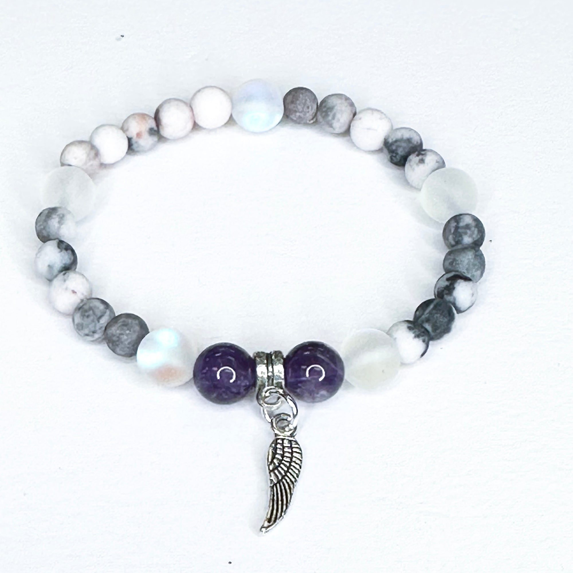 Bracelet with beads and a wing charm on a white background