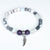 Bracelet with beads and a wing charm on a white background