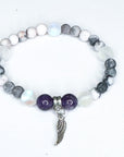 Bracelet with beads and a wing charm on a white background
