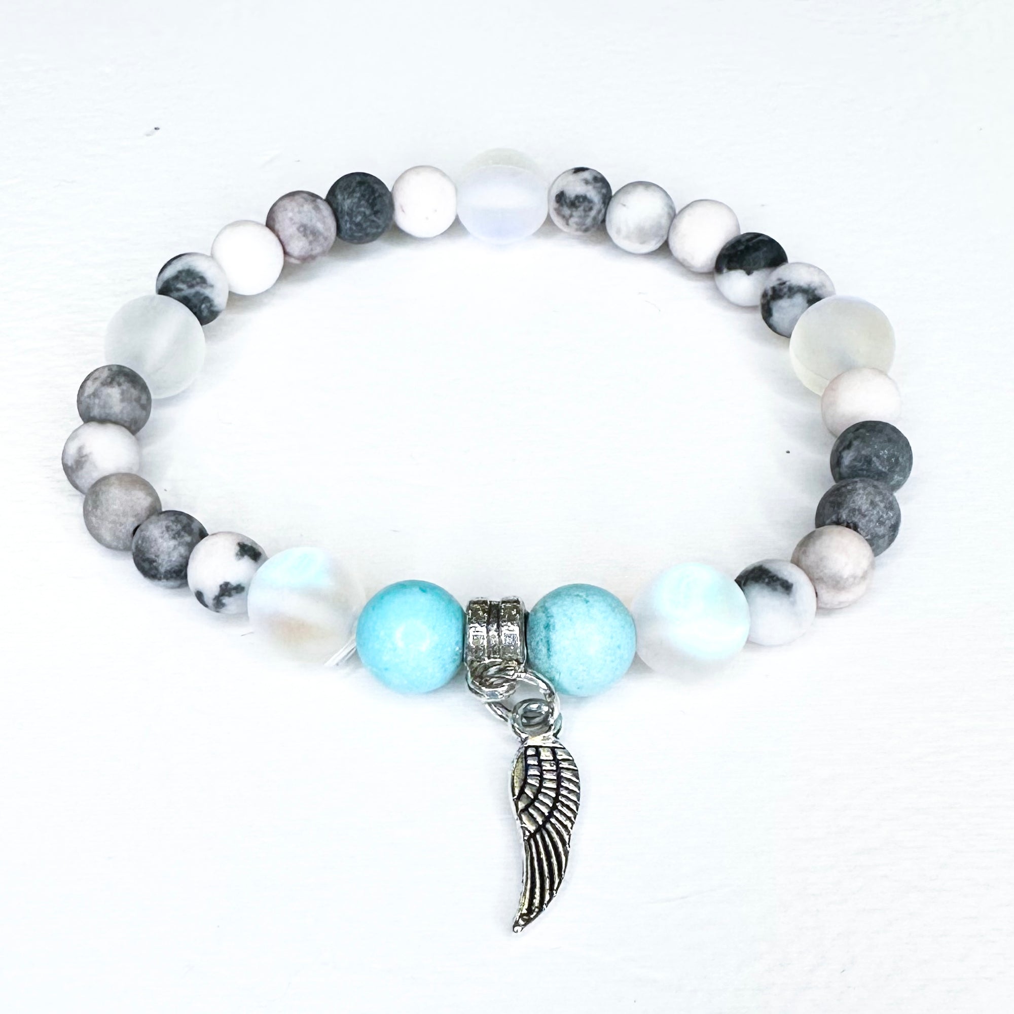 Bracelet with beads and angel wing charm on a white background