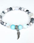 Bracelet with beads and angel wing charm on a white background