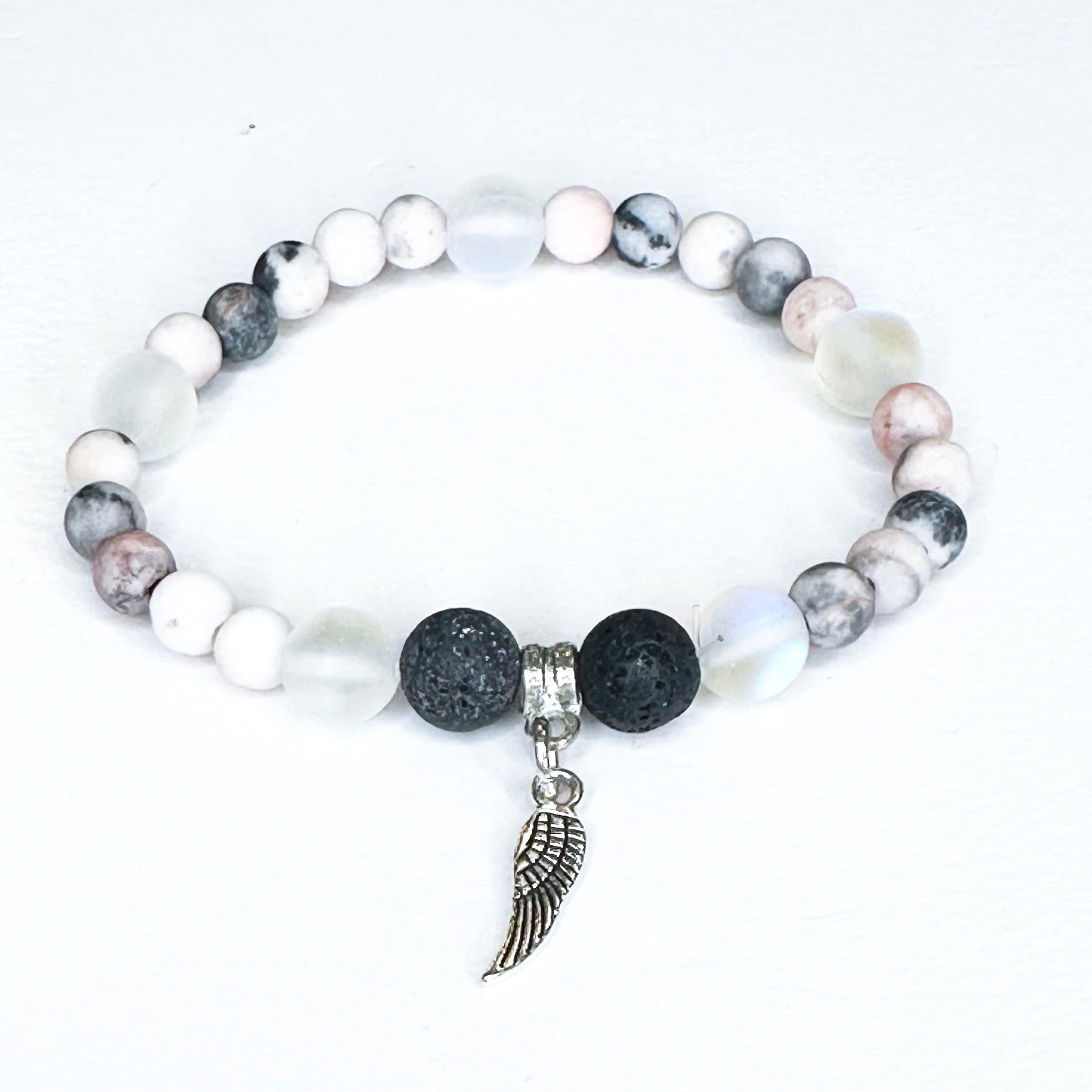 Beaded bracelet with a wing charm on a white background
