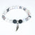 Beaded bracelet with a wing charm on a white background