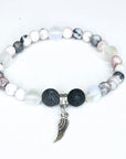 Beaded bracelet with a wing charm on a white background