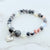 Beaded bracelet with a heart charm on a marble surface