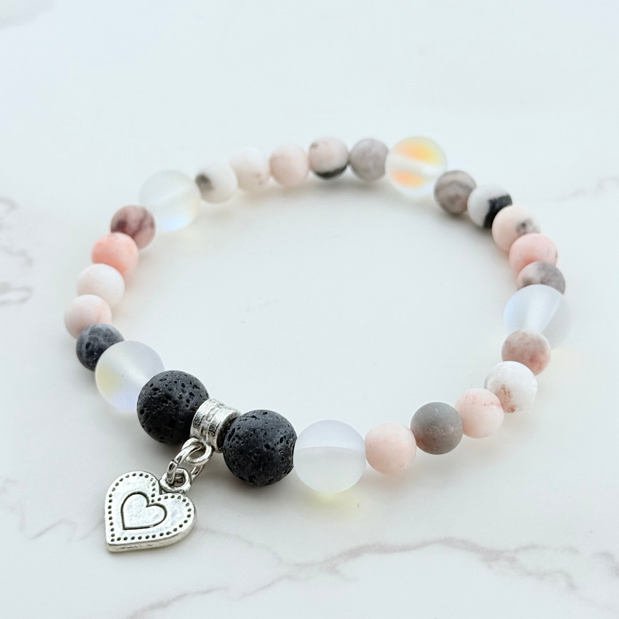 Bracelet with multicolored beads and a heart charm on a light background