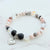 Bracelet with multicolored beads and a heart charm on a light background