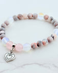 Beaded bracelet with a heart charm on a white background