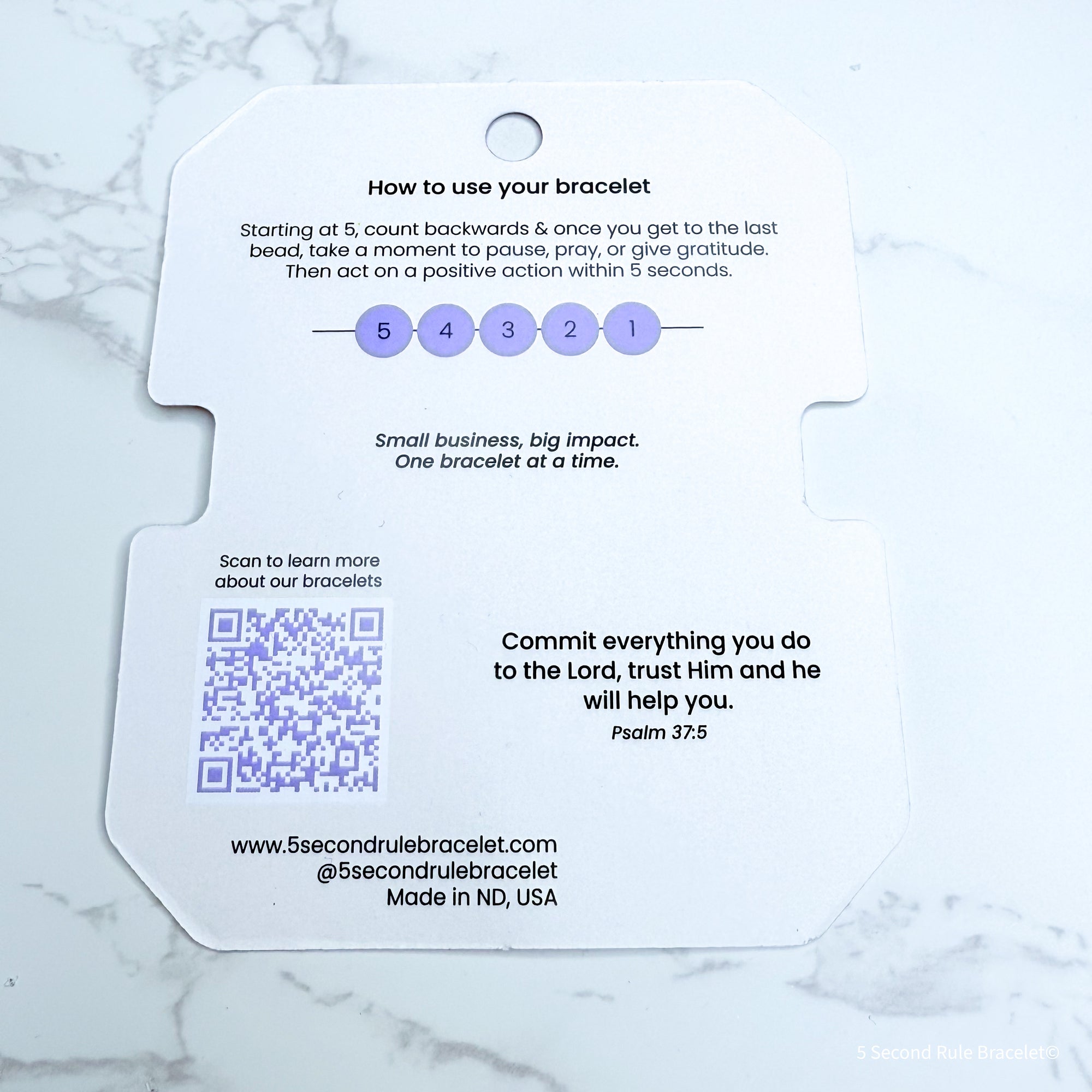Bracelet packaging with instructions and QR code on a marble surface