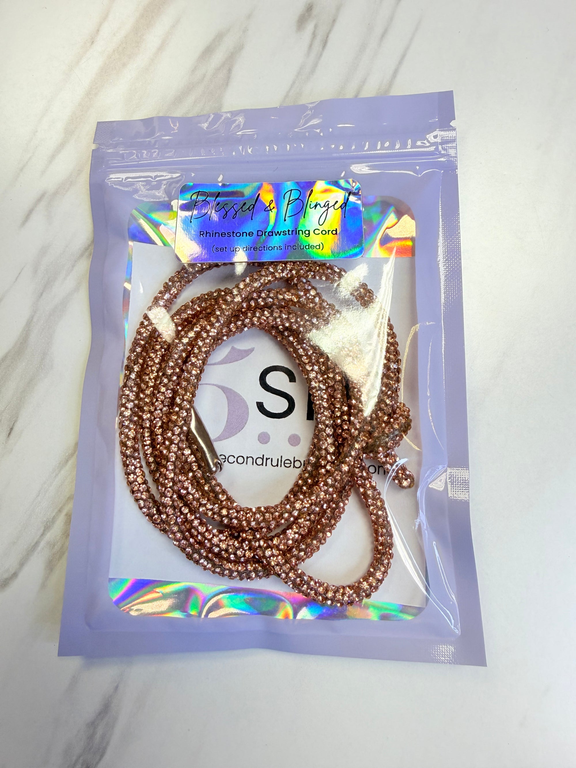 Champagnge hoodie cord in a clear plastic bag with a brand label on a white background