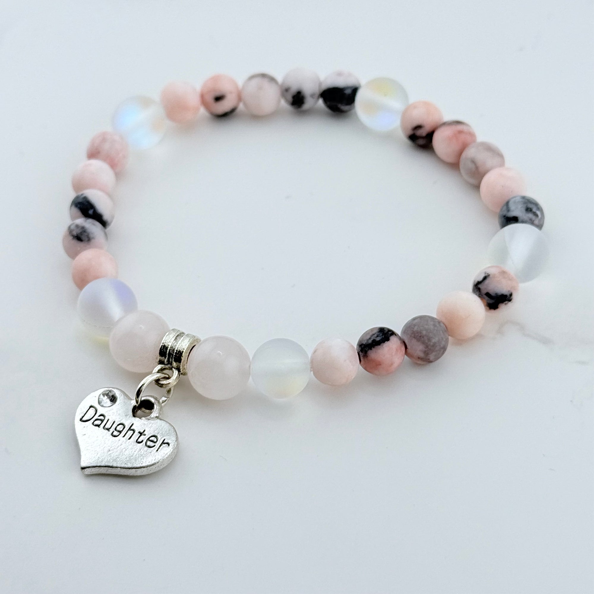 Beaded bracelet with a 'Daughter' charm on a light background