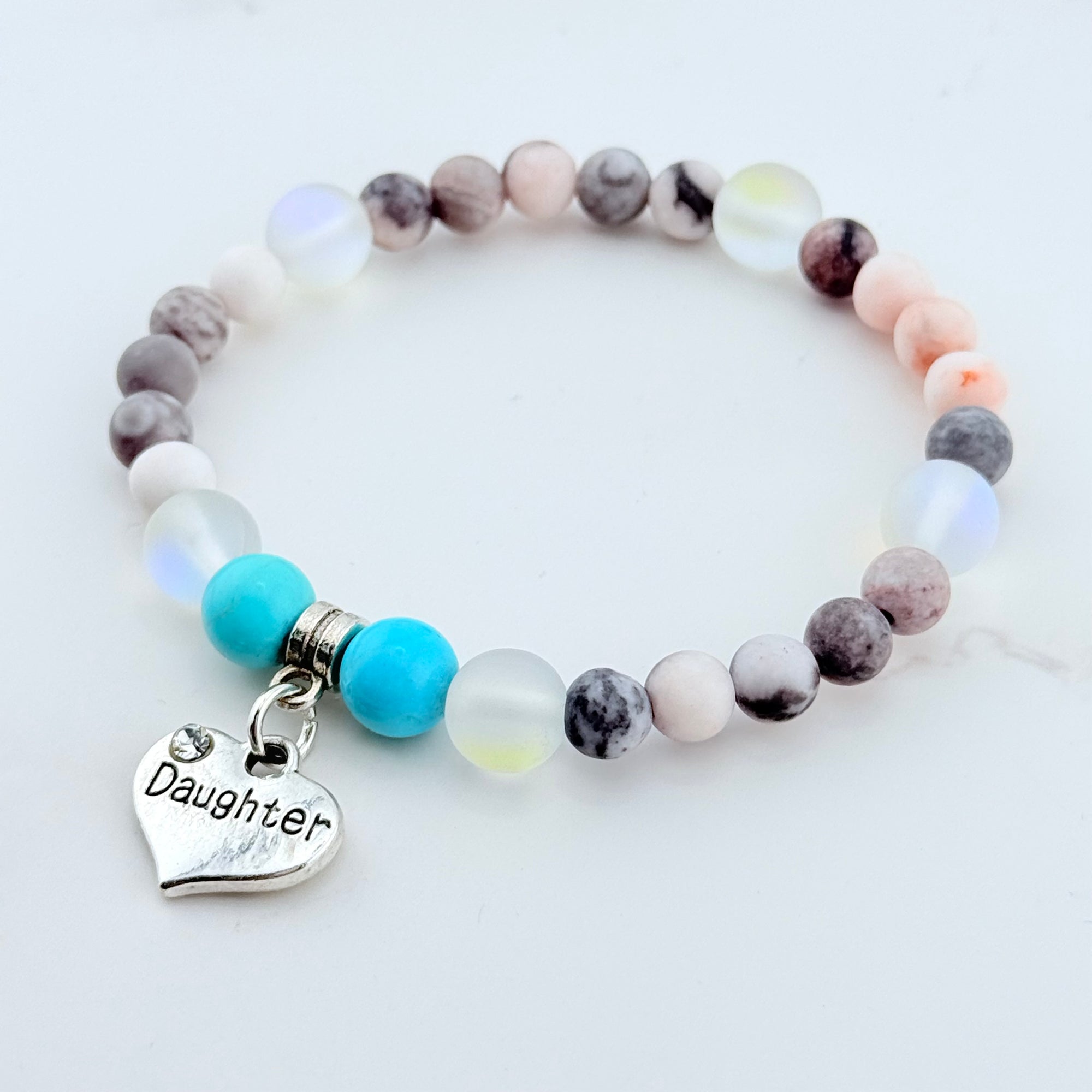 Beaded bracelet with a 'Daughter' charm on a white background