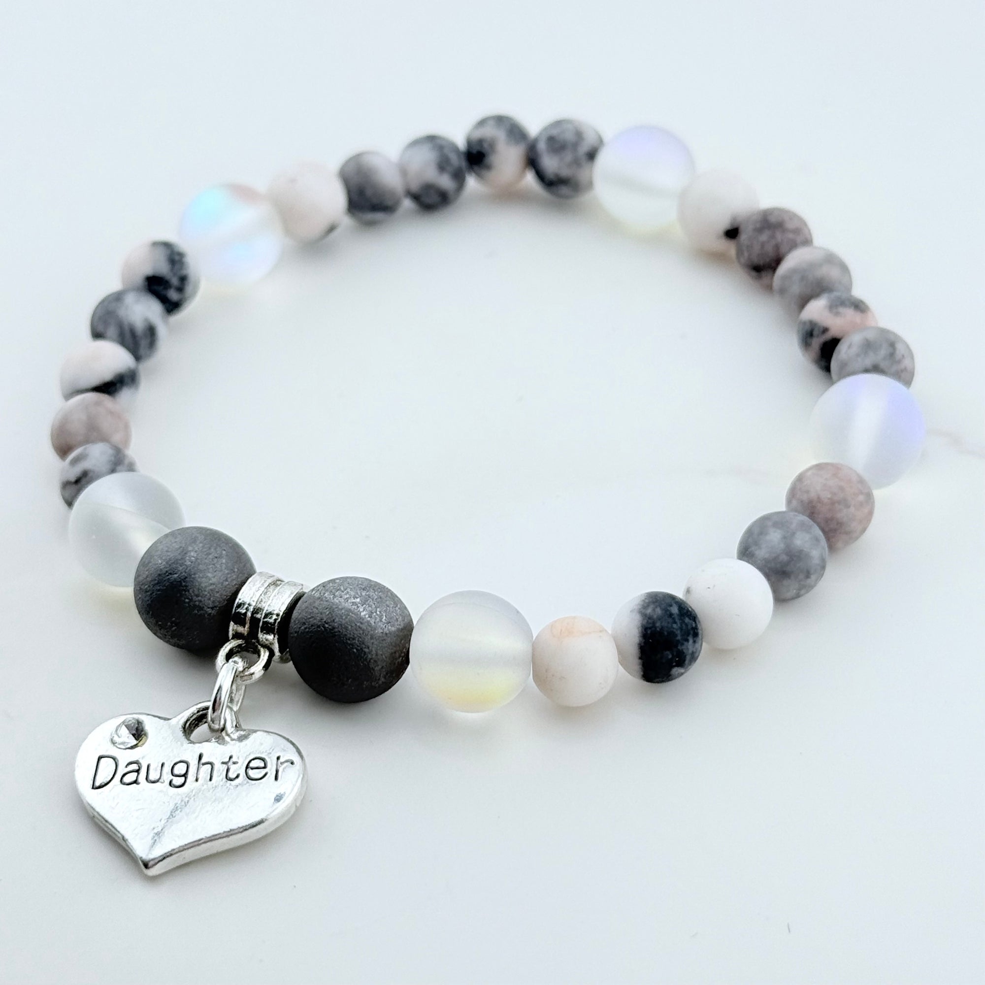 Beaded bracelet with a 'Daughter' charm on a white background