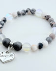 Beaded bracelet with a 'Daughter' charm on a white background