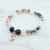 Beaded bracelet with a heart charm on a marble surface