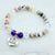 Beaded bracelet with a heart-shaped 'Grand Daughter' charm on a light background