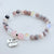 Beaded bracelet with a 'Grandma' charm on a light background