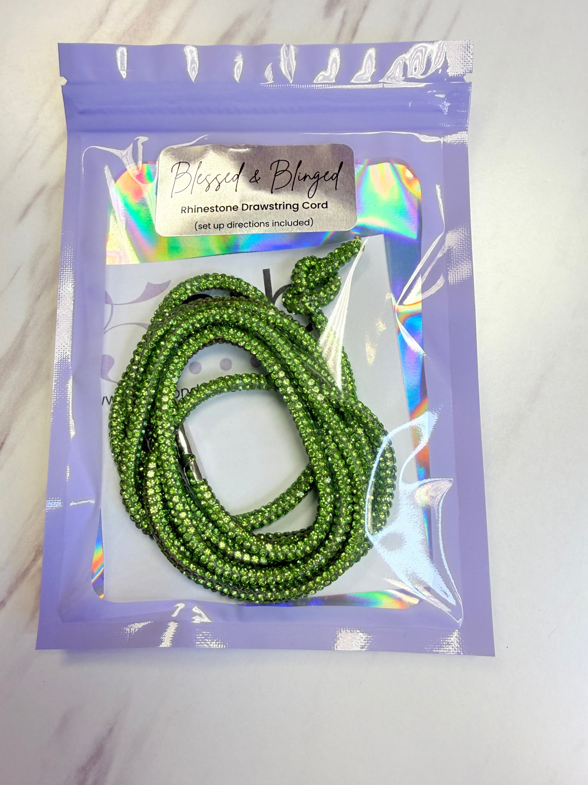 Green beaded cord in a clear plastic bag with a purple label on a white background