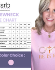 Pink sweatshirt with 'He is Risen' text and size chart for crewneck shirts.