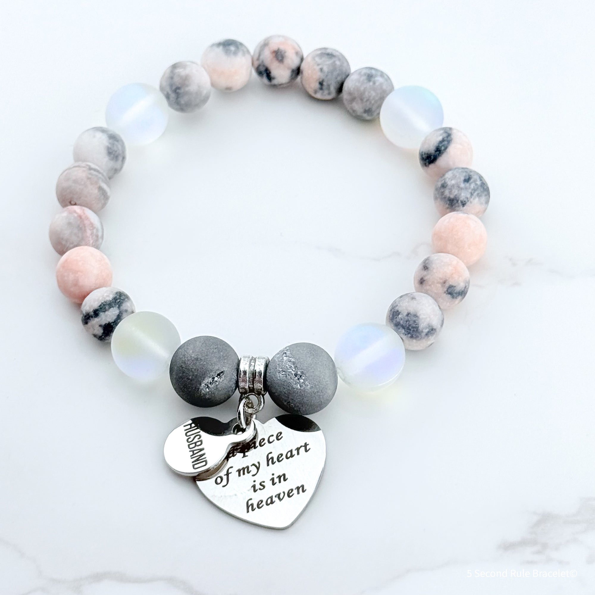 Beaded bracelet with a heart-shaped charm on a white background